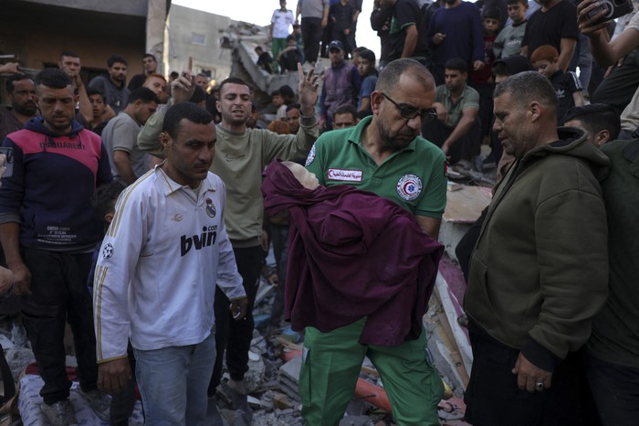 Un rescatista carga el cuerpo de un bebé tras un ataque israelí que impactó la vivienda de una familia palestina en Yabalia · Foto: Bashar Taleb, AFP
