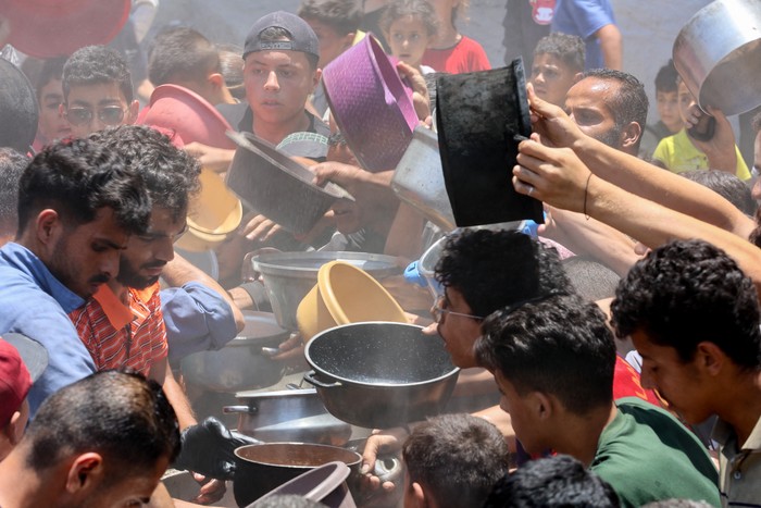 Palestinos intentan conseguir comida en un comedor social, el 18 de junio, en el barrio de Rimal, Gaza. · Foto: Omar Al-Qattaa, AFP