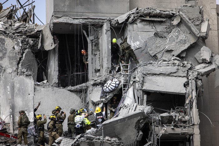 Servicios de emergencia israelíes evacuan un cuerpo de los escombros de un edificio impactado por un misil iraní, el 24 de junio, en Beersheba, al sur de Israel. Foto: John Wessels, AFP.
