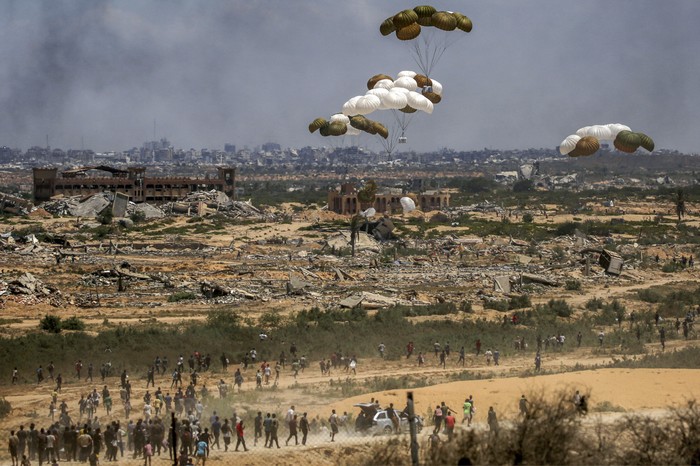 Palestinos reciben ayuda humanitaria en Nuseirat, centro de la Franja de Gaza. · Foto: Eyad Baba, AFP
