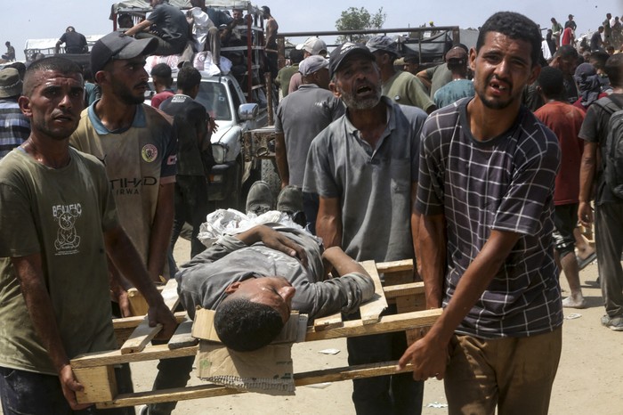 Traslado de un herido en Khan Yunis, sur de la Franja de Gaza, cerca de un puesto de distribución de ayuda. · Foto: Stringer, AFP