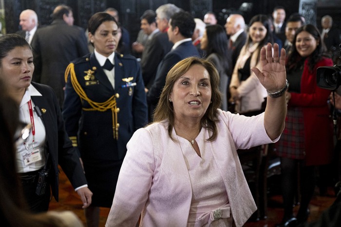 La presidenta peruana, Dina Boluarte, saluda a la prensa tras la ceremonia de promulgación de una ley de amnistía para militares y policías procesados por violaciones de derechos humanos en el Palacio de Gobierno de Lima el 13 de agosto. · Foto: Ernesto Benavides, AFP