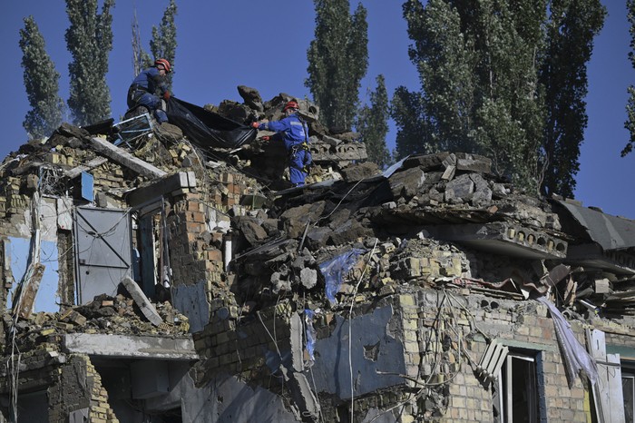 Rescatistas ucranianos durante una operación de búsqueda y rescate en un edificio residencial gravemente dañado tras un ataque con misiles rusos en Kiev. · Foto: Genya Savilov, AFP 