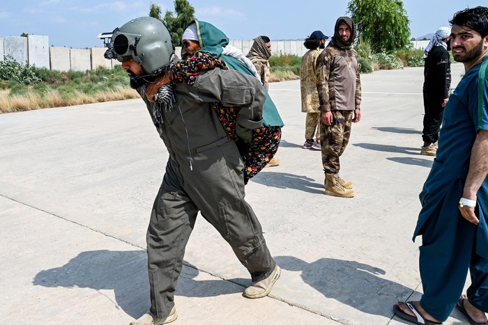 Un militar afgano transporta a una víctima del terremoto, evacuada en helicóptero desde Nurgal, en la provincia de Kunar, tras su llegada a Jalalabad para recibir asistencia médica. Foto: Wakil Kohsar, AFP.