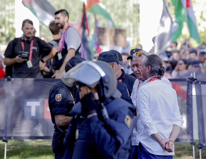 Oficiales de La Vuelta policías en medio de una manifestación pro-palestina previa a la 21.ª y última etapa de la Vuelta a España 2025, en Madrid. · Foto: Pierre-Philippe Marcou, AFP