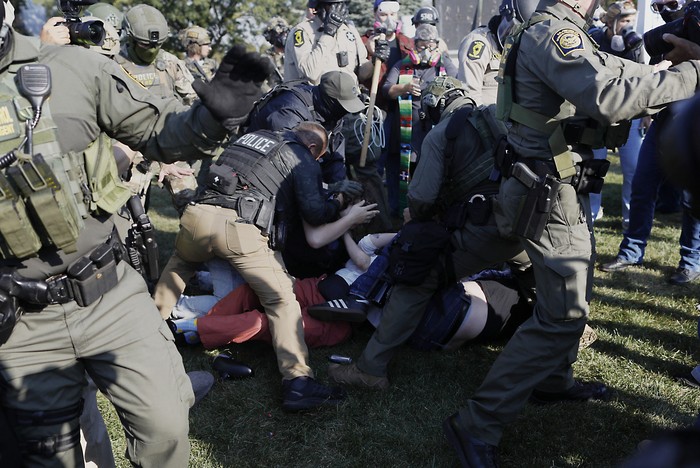 Agentes de Aduanas y Protección Fronteriza de Estados Unidos detienen a manifestantes, el 3 de octubre, mientras cientos de ellos se congregan cerca de una instalación del Servicio de Inmigración y Control de Aduanas en Broadview, Illinois. · Foto: Octavio Jones. AFP