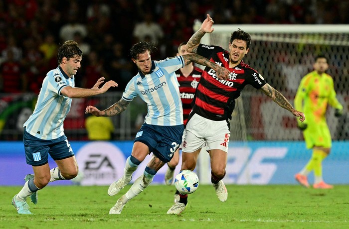 Bruno Zuculini (C) y Santiago Sosa (I), de Racing, y Pedro, de Flamengo, durante el partido de ida de las semifinales de la Copa Libertadores, en el Maracaná de Río de Janeiro, el 22 de octubre. · Foto: Pablo Porciúncula, AFP