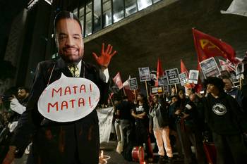 Un manifestante con una máscara del gobernador de Río de Janeiro, Cláudio Castro, el 31 de octubre, durante las movilizaciones en San Pablo. · Foto: Nelson Almeida, AFP