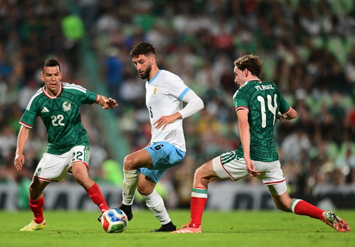Rodrigo Betancur (C), de Uruguay, Hirving Lozano y Marcel Ruiz, de México, el 15 de noviembre, en el partido amistoso internacional en el estadio Corona de Torreón, estado de Coahuila, México. · Foto: Andrés Herrera / AFP
