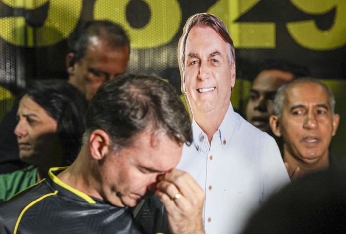 El senador brasileño Flavio Bolsonaro, hijo del expresidente Jair Bolsonaro, gesticula junto a una cartulina durante una vigilia por su salud y libertad , el 22 de noviembre,en Brasilia. · Foto: AFP