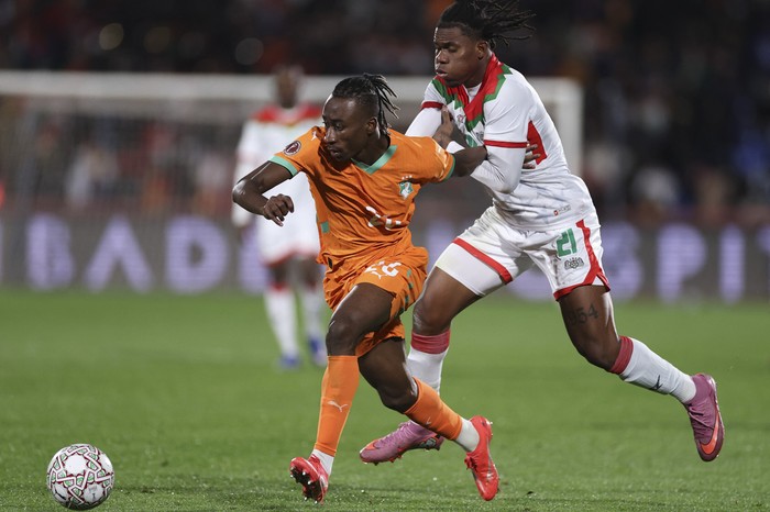 Yan Diomande, de Costa de Marfil, y Cyriaque Irie Bi, de Burkina Faso, durante el partido de octavos de final de la Copa Africana de Naciones en el Gran Estadio de Marrakech. · Foto: Franck Fife,  AFP