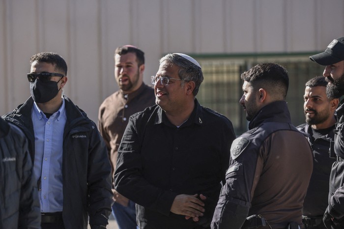 El ministro de Seguridad Nacional de Israel, Itamar Ben Gvir, saluda a las fuerzas de seguridad durante las obras de demolición la sede de la ONU para los refugiados palestinos (UNRWA) en el barrio de Sheikh Jarrah, en Jerusalén Oriental. · Foto: Ilia Yefimovich, AFP