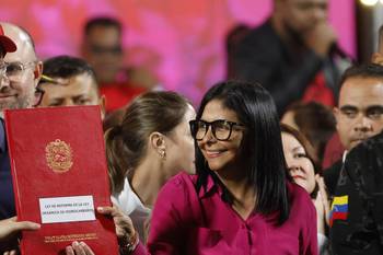 La presidenta encargada de Venezuela, Delcy Rodríguez, sostiene una copia de la reforma de la Ley Orgánica de Hidrocarburos frente al Palacio Presidencial de Miraflores, el 29 de enero. · Foto: Pedro Mattey, AFP