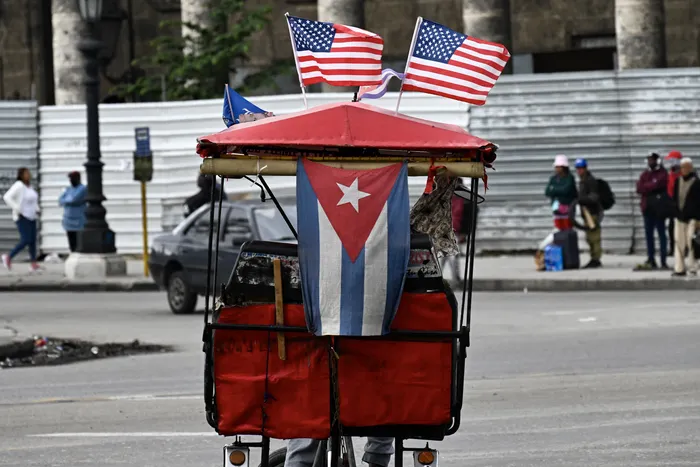 Un triciclo decorado con banderas de Estados Unidos y Cuba en La Habana, el 26 de febrero. · Foto: Yamil Lage, AFP