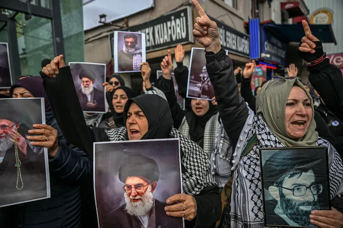 Manifestantes sostienen retratos del ayatolá Alí Jamenei mientras se reúnen para protestar contra el ataque de Estados Unidos e Israel a Irán y el asesinato del líder supremo, frente al consulado de Israel en Estambul, el 1° de marzo. · Foto: AFP
