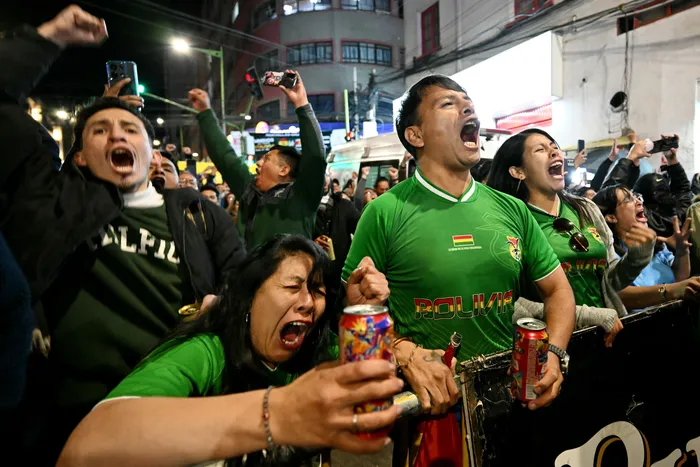 Hinchas bolivianos durante el partido que su selección disputó ante Surinam por las semifinales de las eliminatorias de la Copa Mundial de la FIFA 2026, el 26 de marzo, en una pantalla gigante en La Paz. · Foto: Aizar Raldes, AFP