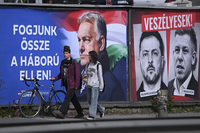 Vallas publicitarias que muestran al primer ministro húngaro Viktor Orbán, con el texto "Unámonos contra la guerra", mientras que retratos del presidente de Ucrania Volodímir Zelenski y del líder de la oposición húngara Peter Magyar, con los textos "Son peligrosos"  y "Detengámoslos, solo Fidesz en el distrito 11 de Budapest el 10 de abril. · Foto: Attila Kisbenedek, AFP