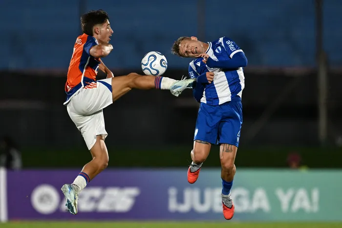 João Barros, de Academia Puerto Cabello, y Facundo Pérez, de Juventud de Las Piedras, por la fase de grupos de la Copa Sudamericana, el 29 de abril, en el estadio Centenario. · Foto: Eitan Abramovich, AFP