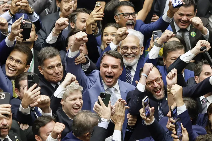 El senador Flavio Bolsonaro (c) celebra durante la sesión del Congreso Nacional, el jueves 30. · Foto: Sergio Lima, AFP