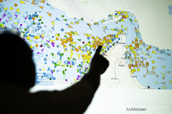 Un hombre señala en una pantalla el movimiento de buques en el Estrecho de Ormuz, el lunes 4. · Foto: AFP