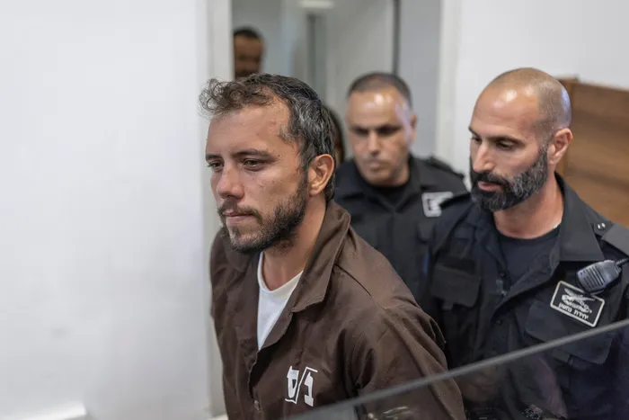 El activista brasileño Thiago Ávila es escoltado al tribunal, ayer,  en la ciudad israelí de Ashkelon. · Foto: Ilia Yefimovich, AFP