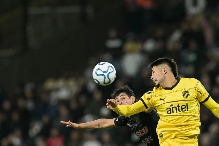 Nicolás Fernández, de Peñarol, y Franco Zapiola, de Platense, durante la fase de grupos de la Copa Libertadores, el 7 de mayo, en el estadio Vicente López. Foto: Juan Mabromata, AFP