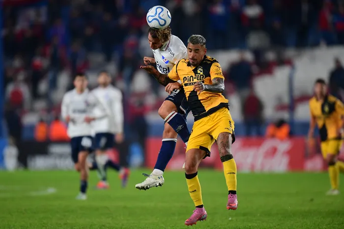 Luciano Boggio, de Nacional y Salvador Cordero, de Coquimbo, el 26 de mayo, por la fase de grupos de la copa Libertadores, en el Gran Parque Central. · Foto: Dante Fernández, AFP