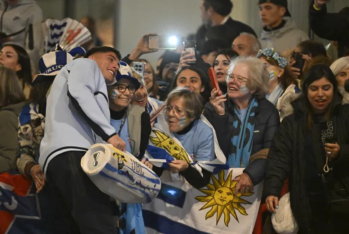 Sergio Rochet junto a hinchas de Uruguay en la despedida de la selección en el Aeropuerto de Carrasco, el 9 de junio. · Foto: Santiago Mazzarovich, AFP