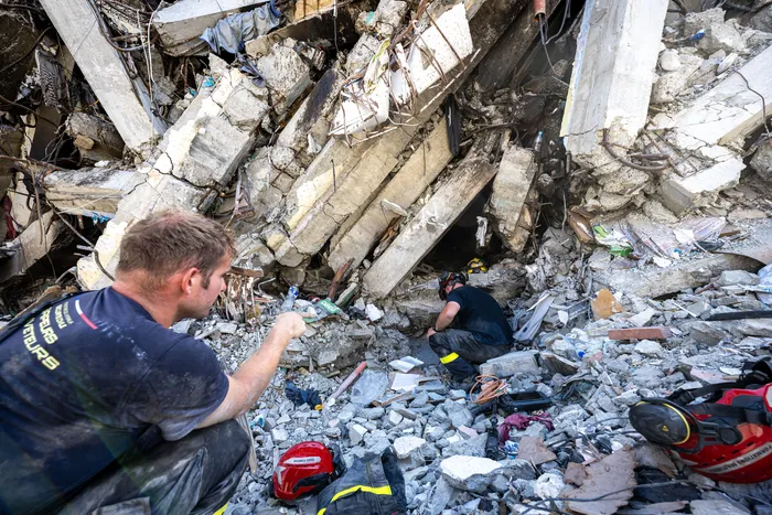 Miembros del 7º Regimiento de Instrucción e Intervención de Seguridad Civil de Francia realizan labores de reconocimiento en un edificio dañado en Catia La Mar, estado de La Guaira, Venezuela, el 29 de junio.  Foto de Miguel Medina, AFP
