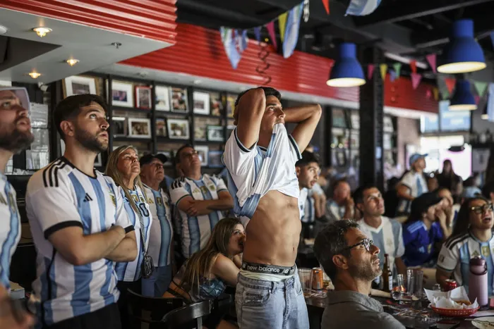 Aficionados argentinos ven el partido de octavos de final entre Argentina y Egipto en un restaurante de Miami Beach. · Foto: Patricia de Melo Moreira, AFP