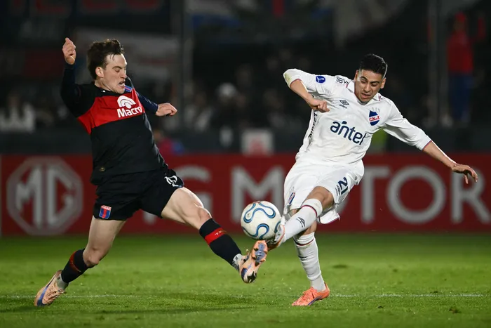 Santiago López, de Tigre, y Camilo Cándido, de Nacional, por la Copa Sudamericana, el 28 de julio, en el estadio José Dellagiovanna en Buenos Aires. · Foto: Luis Robayo, AFP
