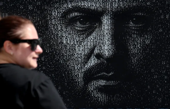 Cartel con la imagen de Volodímir Zelenski compuesto por retratos de militares ucranianos desaparecidos, instalado en la plaza de la Independencia de Kiev el 14 de agosto de 2026. · Foto: Sergei Supinsky, AFP
