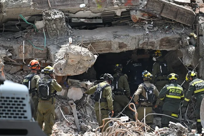 Equipos de rescate de Colombia e Israel buscan entre los escombros, el 18 de agosto, en Cali. · Foto: Joaquín Sarmiento, AFP