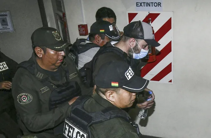 Agentes policiales trasladan a Fernando Cerimedo, desde el Palacio de Justicia a la prisión de Palmasola en Santa Cruz · Foto: Rodrigo Urzagasti, AFP