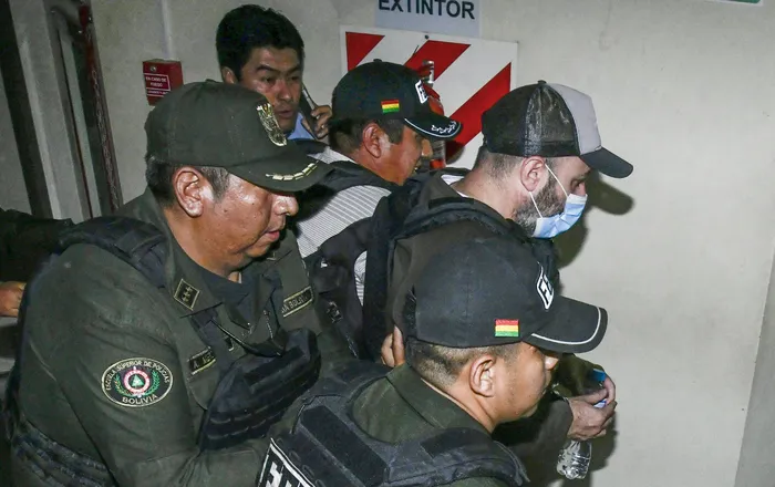 Agentes de policía trasladan a Fernando Cerimedo, asesor cercano del presidente Rodrigo Paz y de nacionalidad argentina, desde el Palacio de Justicia hasta la cárcel de Palmasola en Santa Cruz, Bolivia, el 21 de agosto. · Foto: AFP