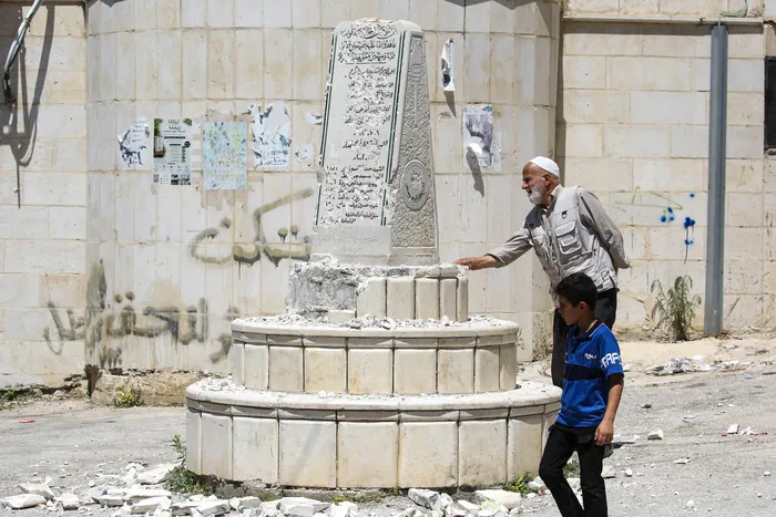 Palestinos inspeccionan los daños en un monumento conmemorativo palestino, destrozado a mazazos por el legislador israelí de extrema derecha Zvi Sukkot y sus acompañantes, el 25 de agosto, en Cisjordania. · Foto: Nedal Eshtayah / AFP