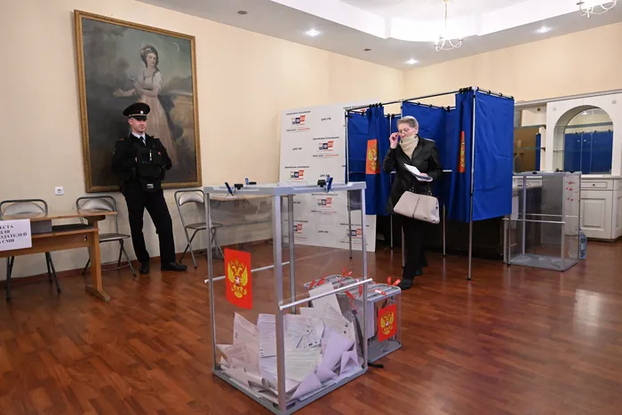 Una mujer sale de una cabina de votación durante las elecciones parlamentarias rusas en un colegio electoral de San Petersburgo, el 18 de septiembre. · Foto: Olga Maltseva, AFP