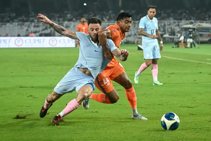 Nahitan Nández, de Uruguay, y Ashique Kuruniyan, de India, durante el partido amistoso, el 6 de octubre,  en el estadio Salt Lake de Calcuta. · Foto: Dibyangshu Sarkar / AFP