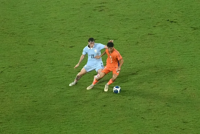 Joaquín Piquerez, de Uruguay, y Pramveer Singh, de India, durante el partido amistoso disputado el 6 de octubre en el estadio Salt Lake de Calcuta. · Foto: Dibyangshu Sarkar / AFP