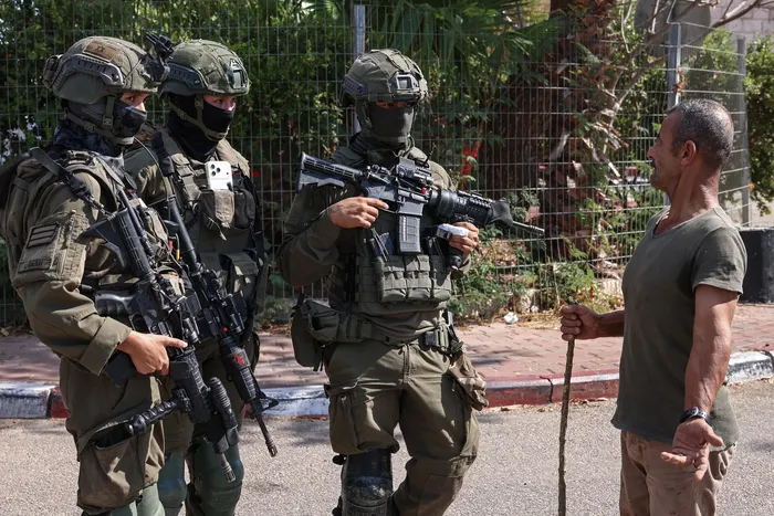 Soldados israelíes durante la recolección de olivos, el 6 de octubre, cerca de Ramala, en Cisjordania. · Foto: Zain Jaafar, AFP