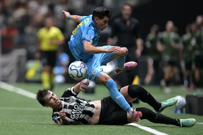 Vitinho, de Atlético Mineiro, y  Esteban Obregón, de Montevideo City Torque, el 14 de octubre, en el estadio Arena MRV de Belo Horizonte. · Foto: Douglas Magno, AFP