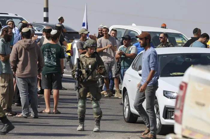 Colonos israelíes en el lugar donde fuerzas israelíes mataron a dos palestinos tras un incidente en un puesto de control al norte de Hebrón. · Foto: Ahmad Gharabli,  AFP