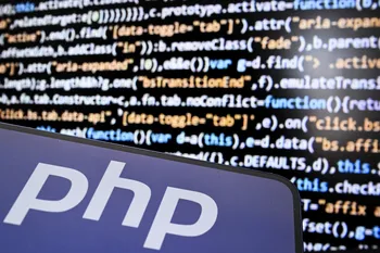 El logotipo PHP (preprocesador de hipertexto) en la pantalla de un teléfono inteligente y un código de computadora. · Foto: Kirill Kudryavstsev, AFP