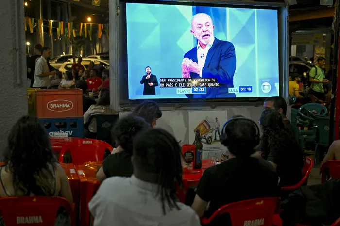 Pantalla en un bar de Brasilia transmitiendo el debate entre Luiz Inácio Lula da Silva y Flávio Bolsonaro, el 23 de octubre. · Foto: Evaristo Sa, AFP