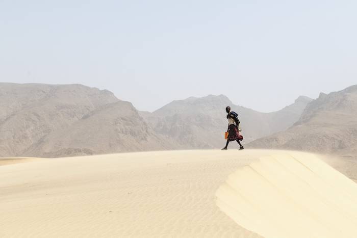 Un hombre transporta un bidón con agua en las dunas de Ceel gerdi, en la costa de Siyara, zona de comercio desde la antigüedad, frente al Golfo de Adén.