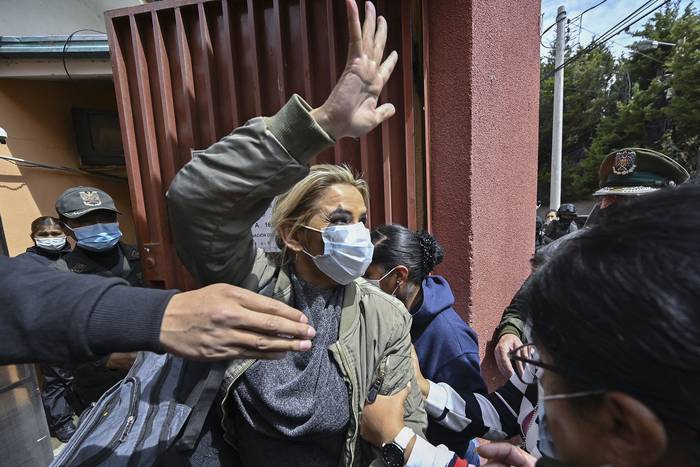 Jeanine Áñez, mientras es escoltada por miembros de la Fuerza Especial Contra el Crimen (FELCC) a la prisión de Obrajes, el 15 de marzo, en La Paz.  · Foto: Aizar Raldes, AFP