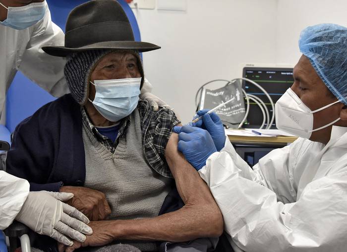 Un anciano es inoculado con la primer dosis de la vacuna Sputnik V, el 24 de mayo, en el Hospital El Alto Sur de El Alto, Bolivia. 
 · Foto: Aizar Raldes, AFP