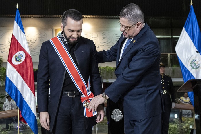 El presidente de El Salvador, Nayib Bukele (i), recibe de manos del presidente de Costa Rica, Rodrigo Chaves, la condecoración de la Orden Nacional Juan Mora Fernández en la casa presidencial de San José, el 11 de noviembre de 2024. · Foto: Ezequiel Becerra, AFP