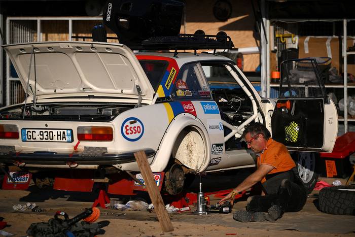 Competidor trabaja en su auto en la víspera de la revisión técnica, el 28 de diciembre, en el campamento cerca de la ciudad de Ynabu, en el Mar Rojo, previo al Rally Dakar 2023. · Foto: Franck Fife, AFP