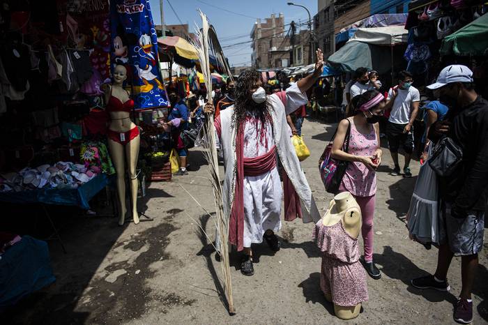 Julio Mario Valencia, candidato al Congreso peruano por el partido Renacimiento Unido Nacional, durante la procesión del vía crucis, el 4 de abril, en un mercado en Lima. · Foto: Ernesto Benavides, AFP
